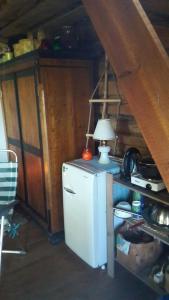 a small refrigerator in a room with a table with a lamp at Kenni Holiday House in Kenni