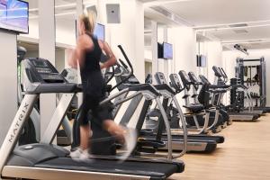 a woman running on a treadmill in a gym at Mayia Exclusive Resort & Spa - Adults Only in Kiotari