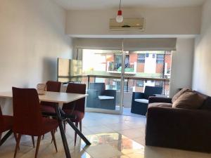 sala de estar con mesa, sillas y sofá en Apartamento Bulnes y Calle Corrientes en Buenos Aires