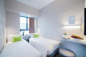 a hotel room with two beds and a bowl of fruit at Hotel Ease Mong Kok in Hong Kong