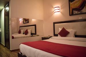 a hotel room with two beds with red pillows at Al Murjan Palace Hotel Jounieh in Jounieh
