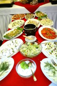 uma mesa vermelha com pratos e tigelas de comida em Ośrodek Wypoczynkowy Rzemieślnik em Szklarska Poręba