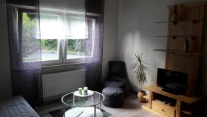 a living room with a glass table and a window at Ferienwohnung Seibt in Plettenberg