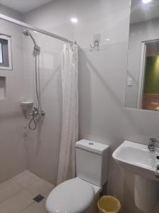 a white bathroom with a toilet and a sink at Westpoint Hotel in Cebu City