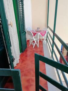 balcone con tavolo e sedie. di Casa Flavin Favignana a Favignana