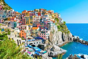 a group of colorful houses on a hill next to the ocean at affittacamere BABY in La Spezia