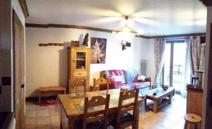 a living room with a table and a couch at les 7 laux immobilier chalet B in Prapoutel