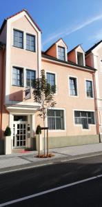 un edificio con un árbol frente a una calle en City Hotel Neuwied, en Neuwied