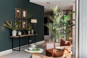 a lobby with two chairs and a table and plants at Vincci Selección Posada del Patio in Málaga