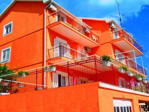 un edificio arancione con balconi sul lato di Apartments Sun Igalo Montenegro a Igalo