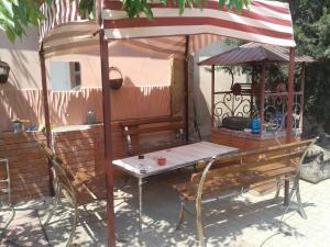 una mesa y sillas bajo una sombrilla junto a un banco en Минигостиница, en Kryzhanivka