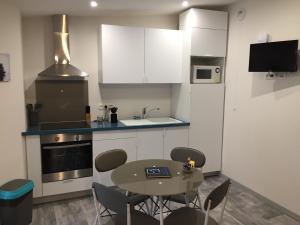 a kitchen with a table and chairs in a room at La Bastidasse in La Roquette-sur-Siagne