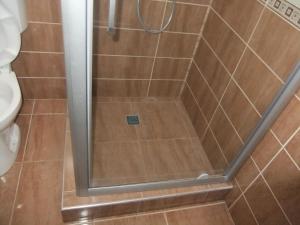 a shower with a glass door in a bathroom at APARTAMENT REBEKA in Mamaia Nord