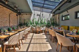 a restaurant with wooden tables and chairs and plants at Reverence Boutique Hotel in Varna City