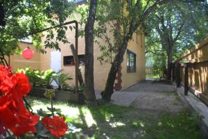 un bâtiment avec des arbres et des fleurs rouges dans une cour dans l'établissement Karusselli Beach Area Holiday Home, à Pärnu