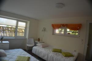 a bedroom with two beds and two windows at Karusselli Beach Area Holiday Home in Pärnu