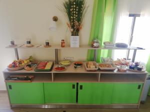 a display cabinet with food on it with green walls at Sensations Guesthouse in Lagos