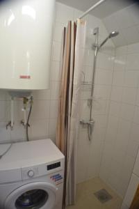 ein Badezimmer mit Waschmaschine und Dusche in der Unterkunft Karusselli Beach Area Holiday Home in Pärnu