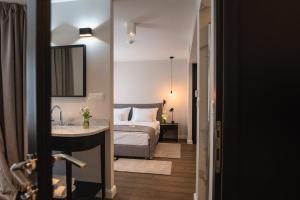 a bedroom with a bed and a bathroom with a sink at Hotel Florian&Godler in Karlovac