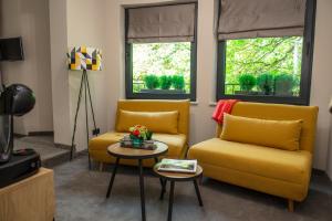 a living room with two yellow chairs and a table at Reverence Boutique Hotel in Varna City
