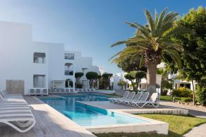 basen z białymi krzesłami i palmą w obiekcie Hotel Palia Dolce Farniente 3 Sup w mieście Cala d´Or
