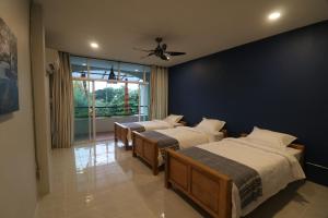 a bedroom with three beds and a ceiling fan at Little Jasmine by the River in Phitsanulok