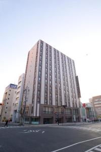 a large building on the corner of a street at Shizutetsu Hotel Prezio Shizuoka Ekinan in Shizuoka