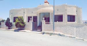 ein großes weißes Haus an der Straßenseite in der Unterkunft Petra Villa in Wadi Musa