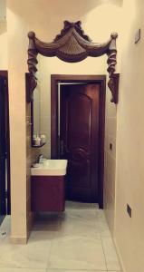 a bathroom with a sink and a wooden door at Petra Villa in Wadi Musa