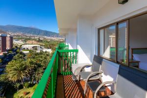 a balcony with two chairs and a view of the city at Sol Puerto de la Cruz Tenerife in Puerto de la Cruz
