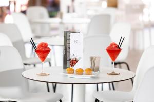 a table with two cocktails and a book and cupcakes at Sol Puerto de la Cruz Tenerife in Puerto de la Cruz