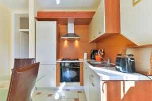 a small kitchen with a stove and a sink at Apartments Đaković in Pakoštane