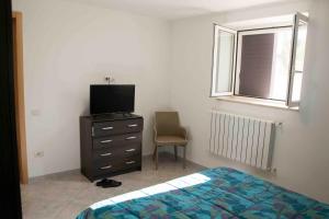 - une chambre avec un lit, une télévision et une chaise dans l'établissement Emyhouse54, à Martina Franca