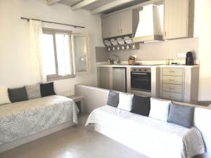 a living room with a couch and a kitchen at Notos Villa in Schinoussa