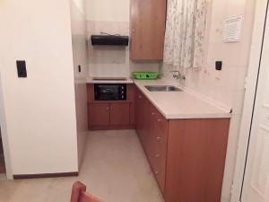 a small kitchen with a sink and a microwave at ARTEMIS Studios & Apartments Sidari in Sidari