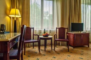 a hotel room with a table and chairs and a television at Mechta Teya in Kerch