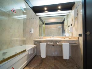 a bathroom with two sinks and a mirror at Sercotel Hotel Bahía de Vigo in Vigo