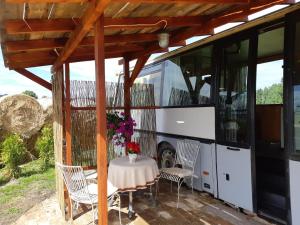 a bus parked next to a table and a bus at Atomi CountryBus in Aucugals