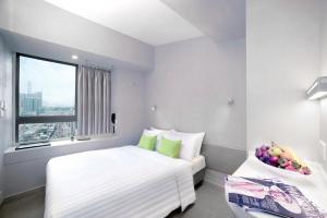 a hotel room with a bed and a bowl of fruit on a table at Hotel Ease Mong Kok in Hong Kong