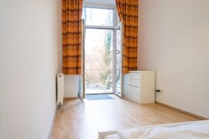 une chambre vide avec un lit et une grande fenêtre dans l'établissement Tulpen Residenz, à Offenbach-sur-le-Main