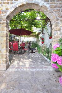 an archway with a patio with an umbrella and a cat under it at Cozy Istrian House in Izola