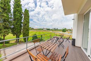 a balcony with chairs and tables and a view of a field at HI Viseu - Pousada de Juventude in Viseu