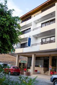 a building with a red car parked in front of it at LT Aparthotel in Praia