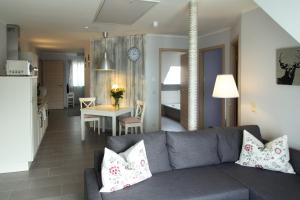 a living room with a gray couch and a kitchen at Villa-Meehr in Bantikow