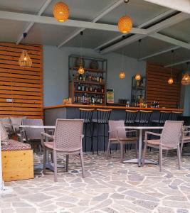 un restaurante con mesas y sillas y un bar en Dream House, en Agia Paraskevi