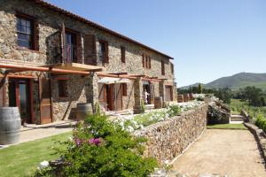 an old stone house with a stone wall at Casa Mori House in Stellenbosch