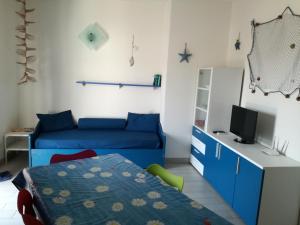a bedroom with a blue bed and a television at Le Rose Marine in Isola Rossa