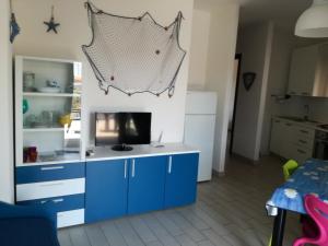 una cocina con un armario azul con TV. en Le Rose Marine en Isola Rossa