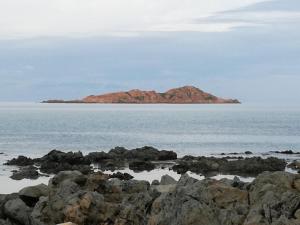 una isla en medio del océano con rocas en Le Rose Marine, en Isola Rossa