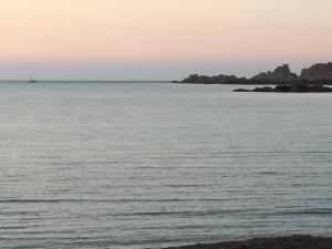 a large body of water with an island in the distance at Le Rose Marine in Isola Rossa